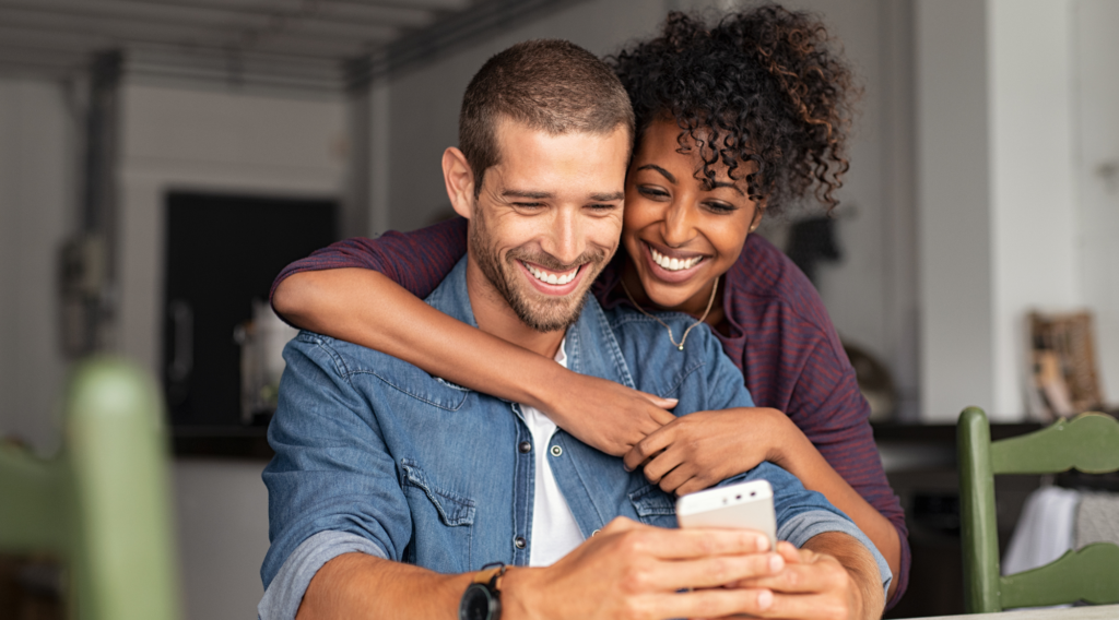 Couple smiling looking at phone