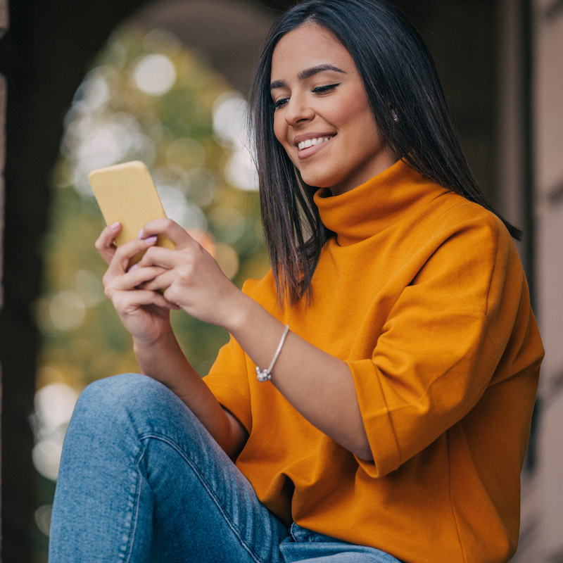 Woman smiles at smartphone