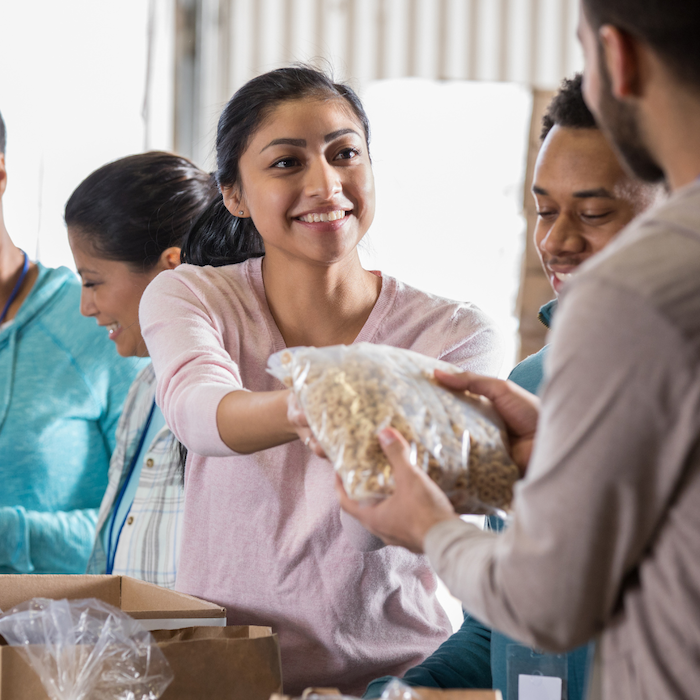 Volunteer hands out food at a foodbank