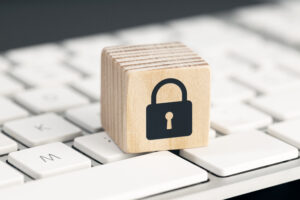 Computer Security protection concept. Cyber attack protection. Closed padlock icon on wooden block on computer keyboard